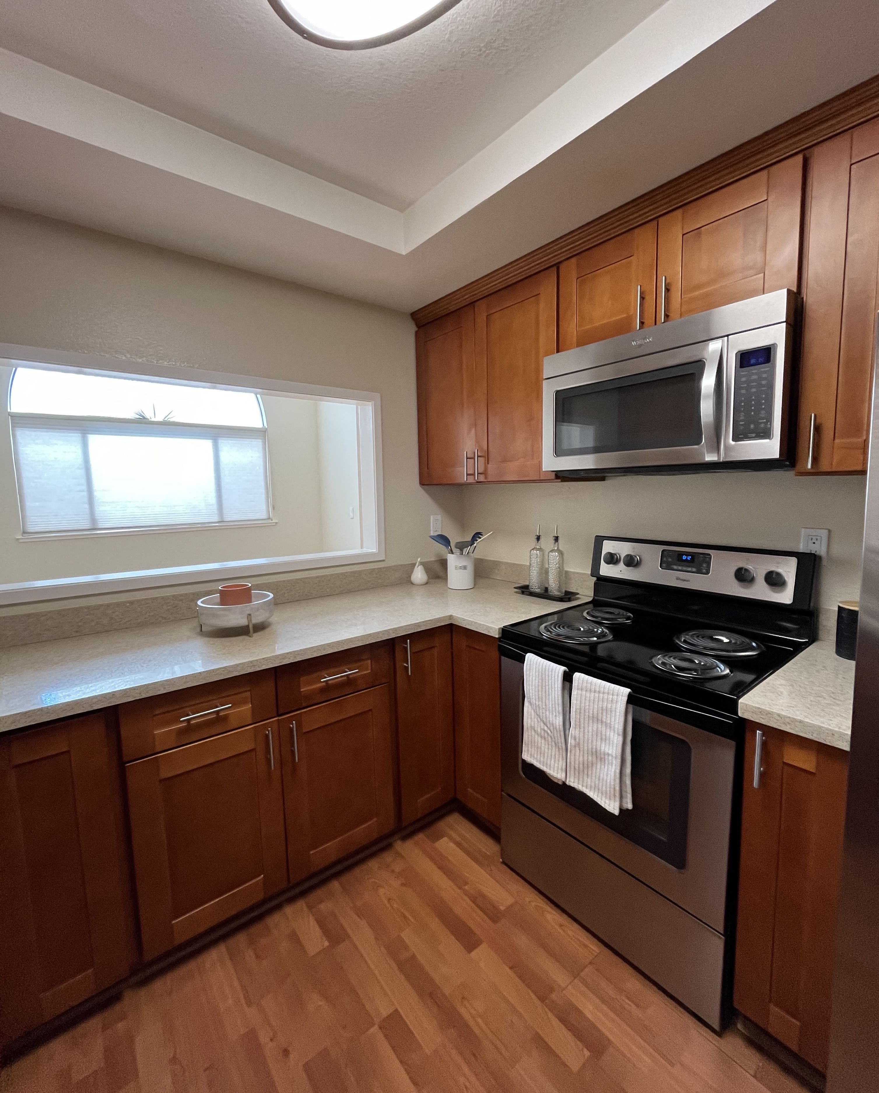 A kitchen with wooden cabinets and a black stove top oven.